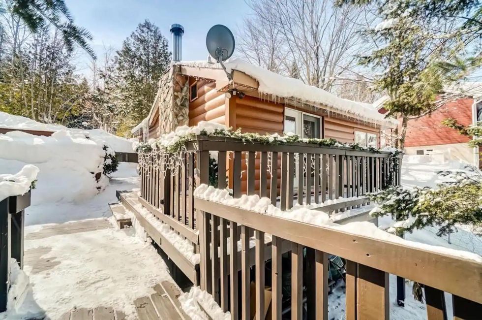 Cozy cabin Airbnb covered in snow.