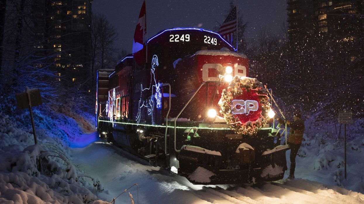 cpkc holiday train lit up at night on snow covered tracks in canada