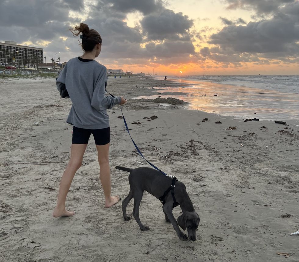 Cristiano walking her dog on a beach in Galveston, TX.