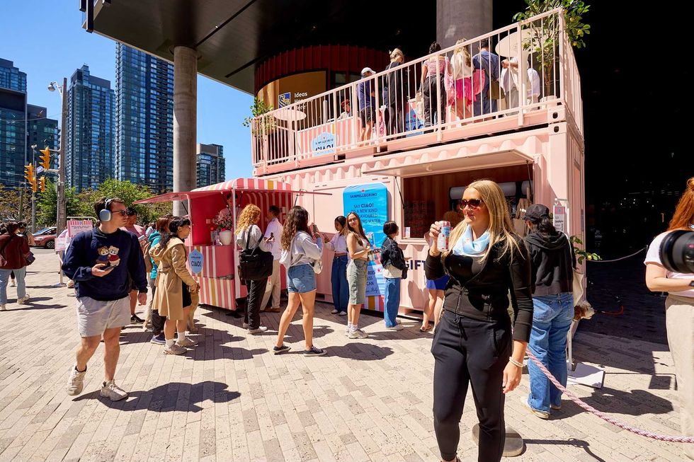Crowd gathered at the Sanpellegrino Ciao! pink pop-up activation in downtown Toronto, featuring beverage sampling and branded displays.