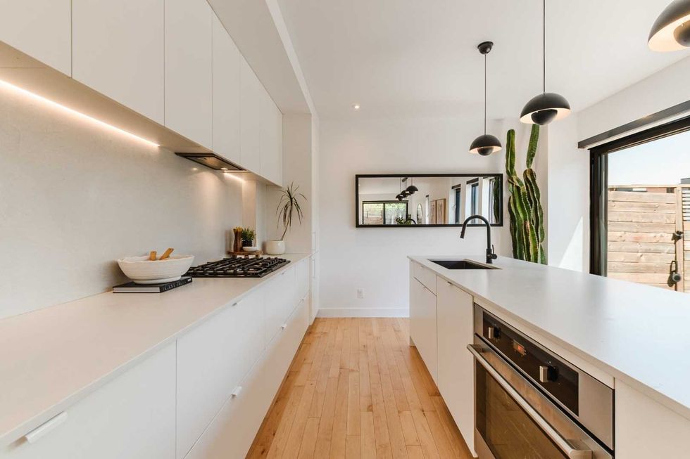 Cuisine minimaliste avec \u00eelot de quartz dans la maison de Lysandre Nadeau et Claude B\u00e9gin.