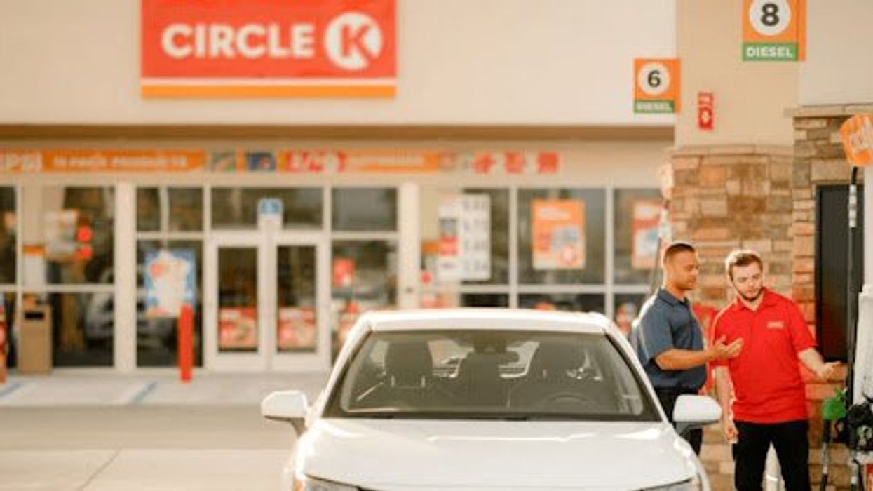 Customers refuel at a Circle K gas station with assistance from friendly staff.