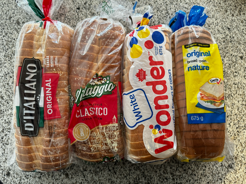 D'italiano, Villaggio, Wonder, and no name loaves of white bread on a countertop.