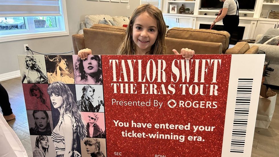 Dana Caputo's daughter poses with a novelty ticket to Taylor Swift | The Eras Tour.