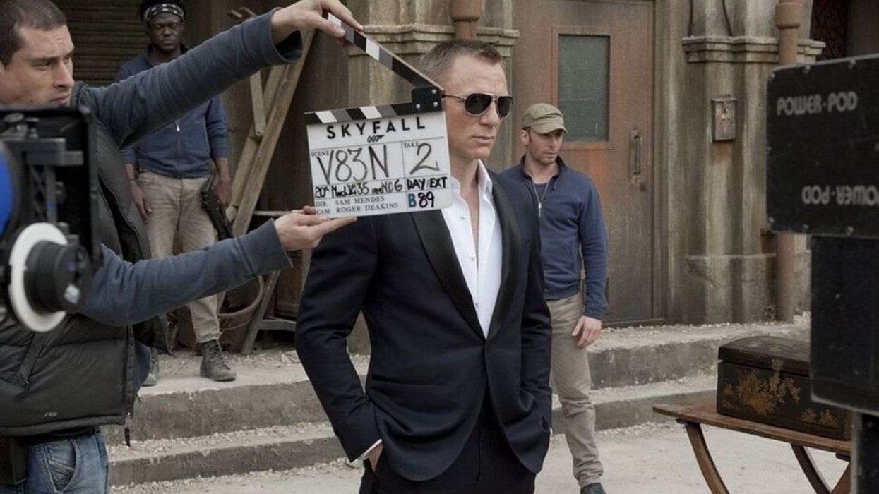 Daniel Craig about to shoot a scene for the James Bond film "Skyfall" as a production member holds up a clap board in front of him.
