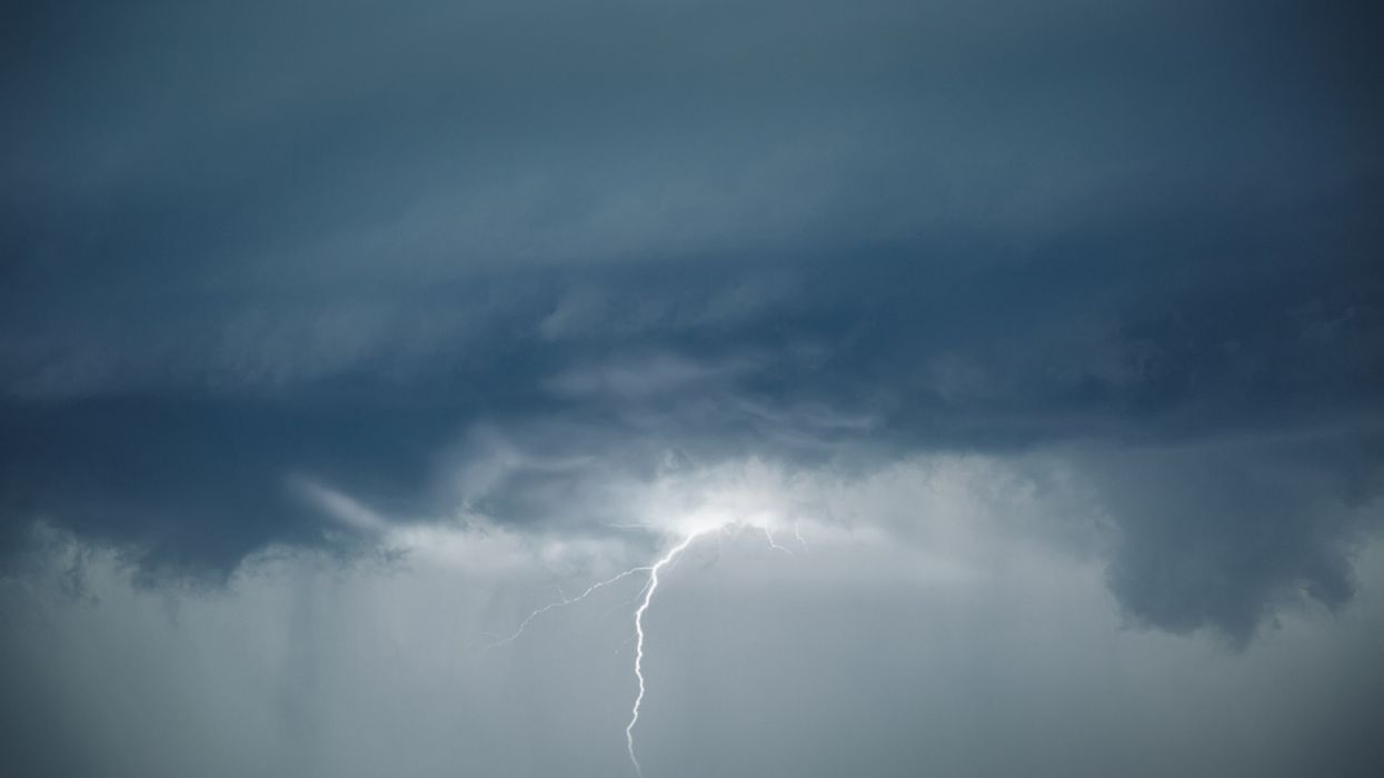 Dark storm clouds with tornadoes forming and a bolt of lightning.