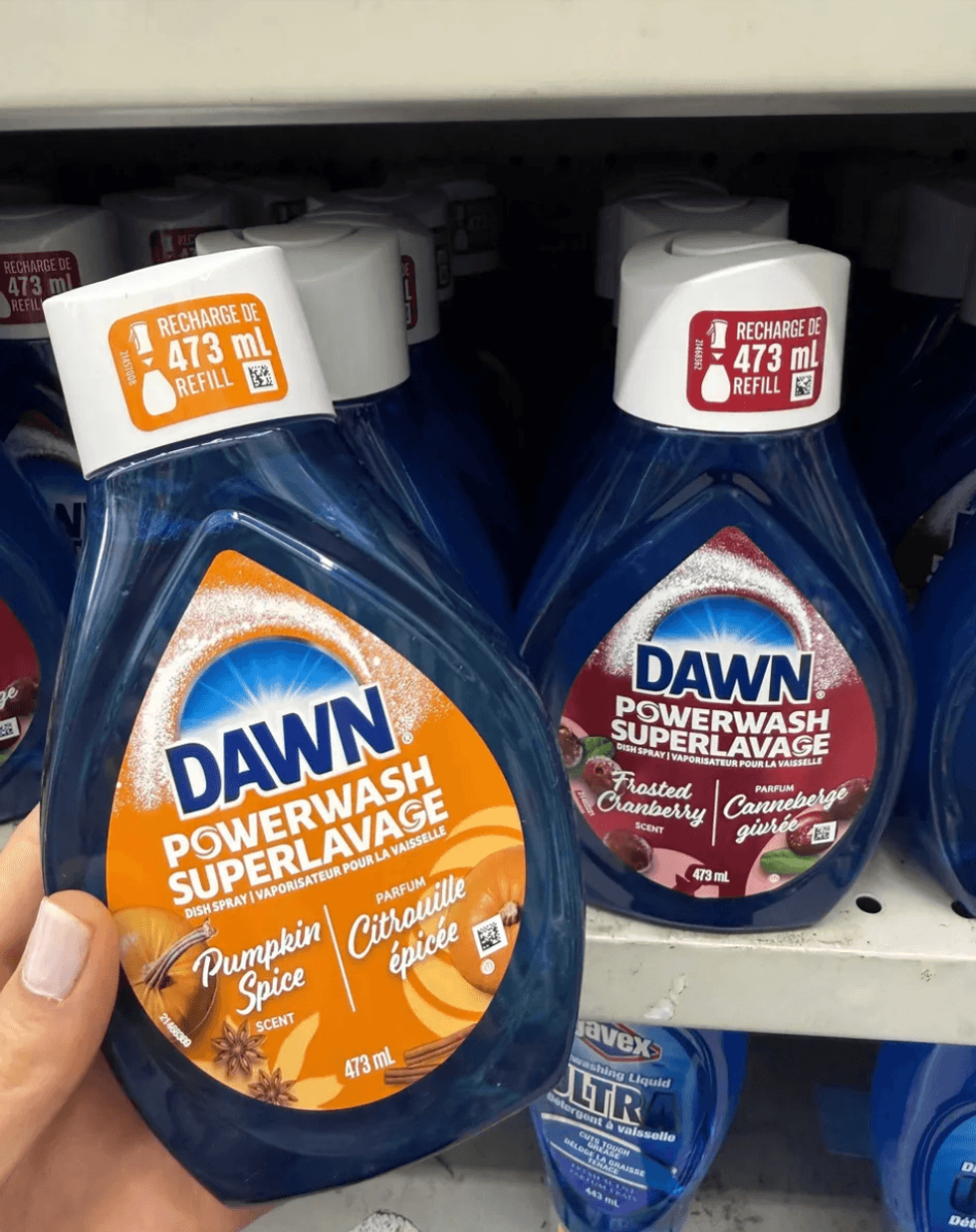 Dawn Powerwash bottles in Pumpkin Spice and Frosted Cranberry scents on a store shelf.
