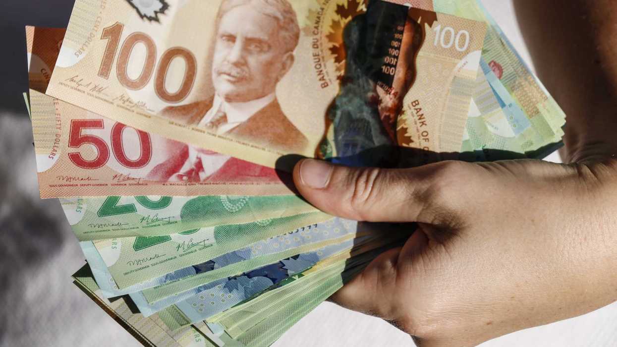 De l'argent canadien dans une main.