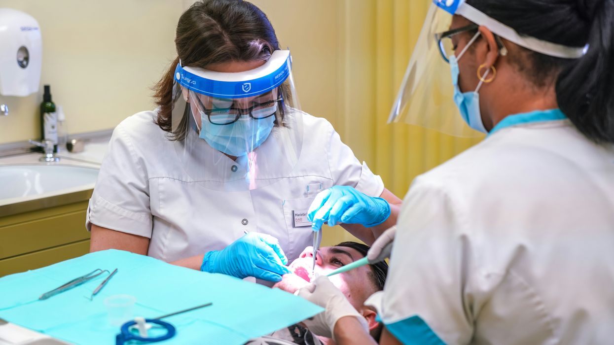 Dentist performs a procedure on a patient.