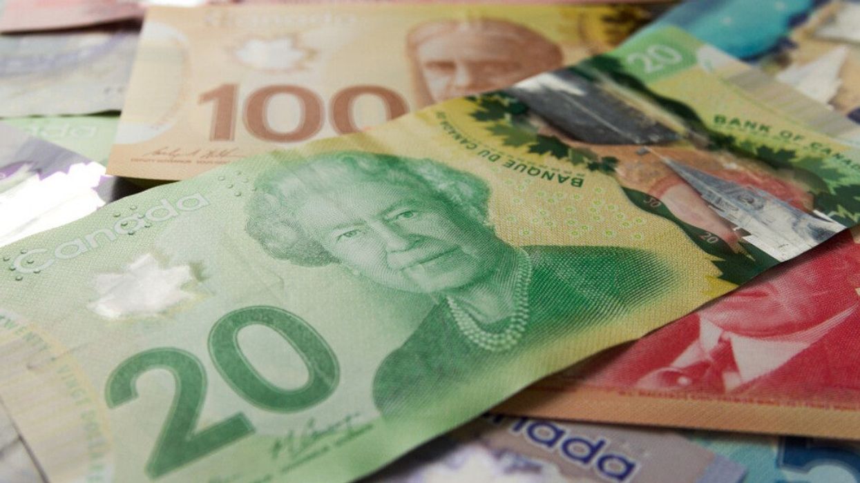Des billets d'argent canadien dispersés sur une surface plane.