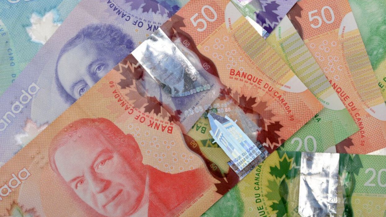 Des billets d'argent canadien étalés sur une surface plate.