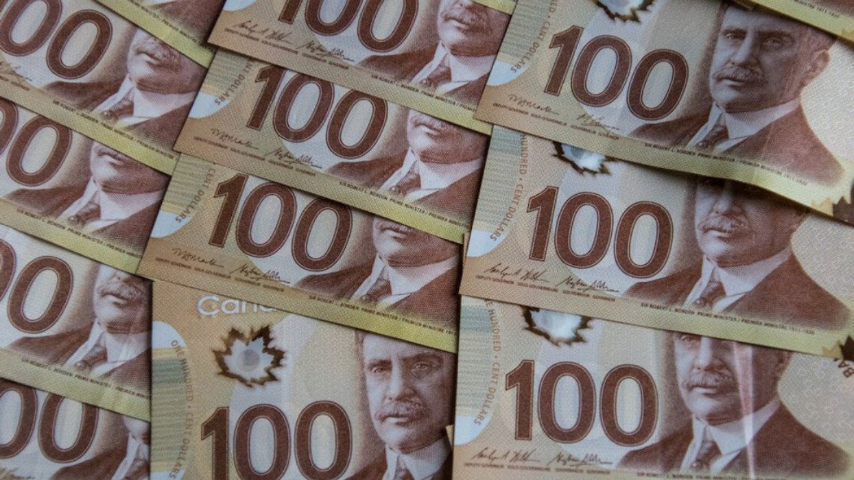 Des billets de 100 $ dispensés sur une surface plate.
