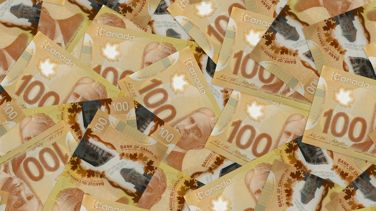 Des billets de 100 $ étalés sur une surface plane.