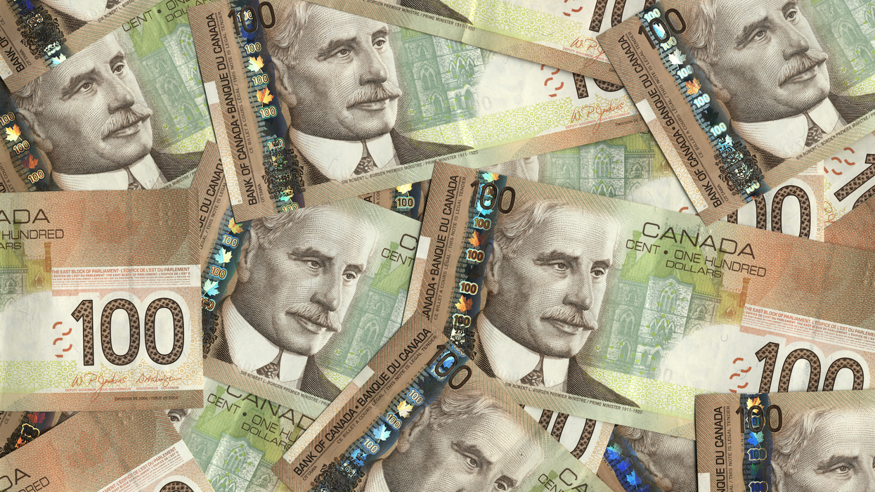 Des billets de 100 $ étalés sur une surface plane.