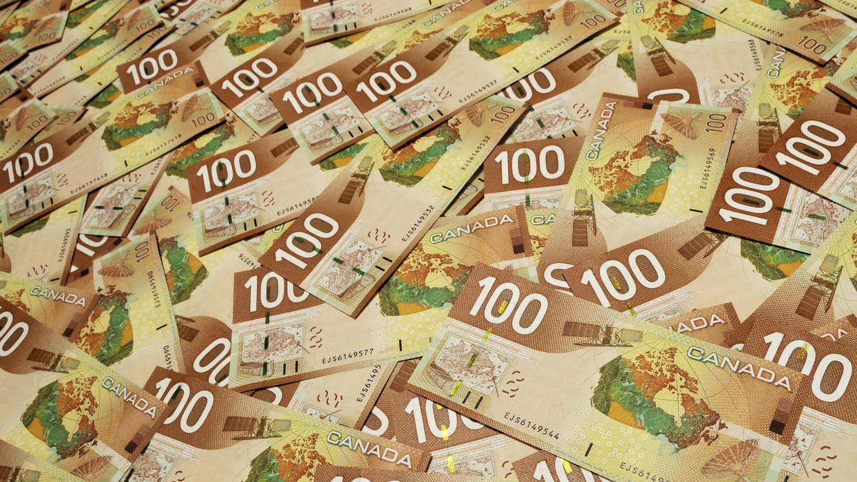 Des billets de 100 $ étalés sur une surface plane.