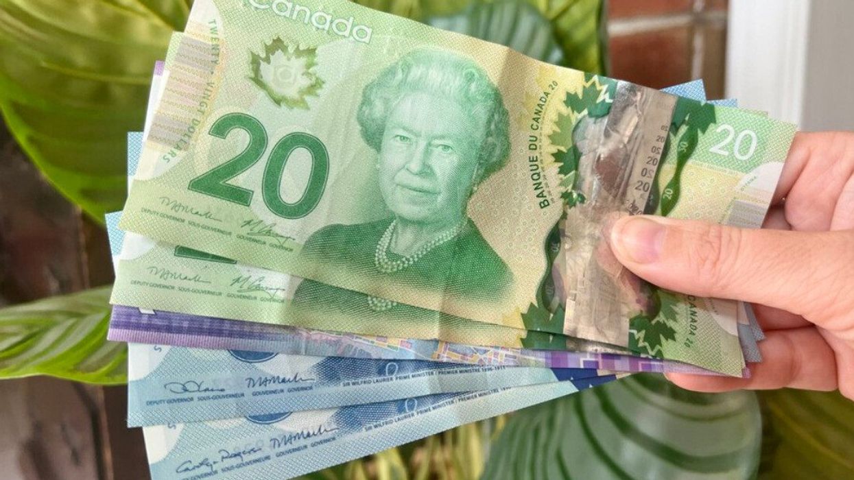 Des billets de 20 $, 10 $ et 5 $ placés en éventail dans une main.