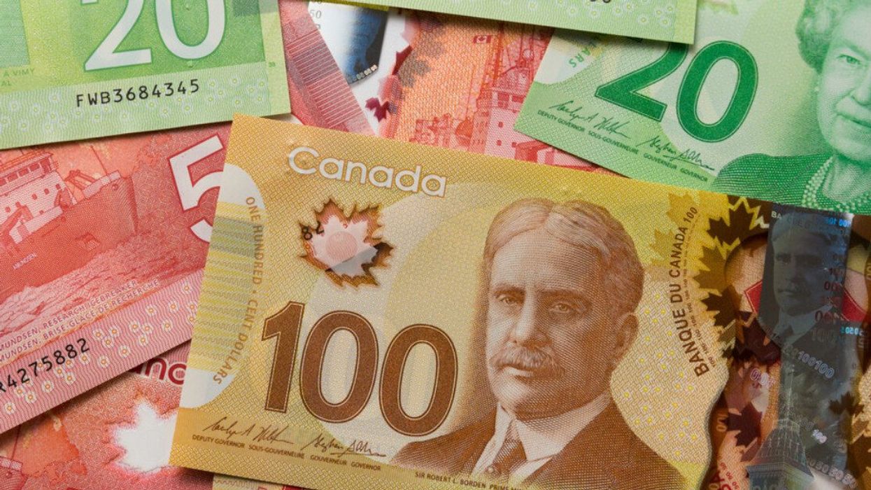 Des billets de 20 $, 50 $ et 100 $ canadien sont dispersés sur une surface plane.