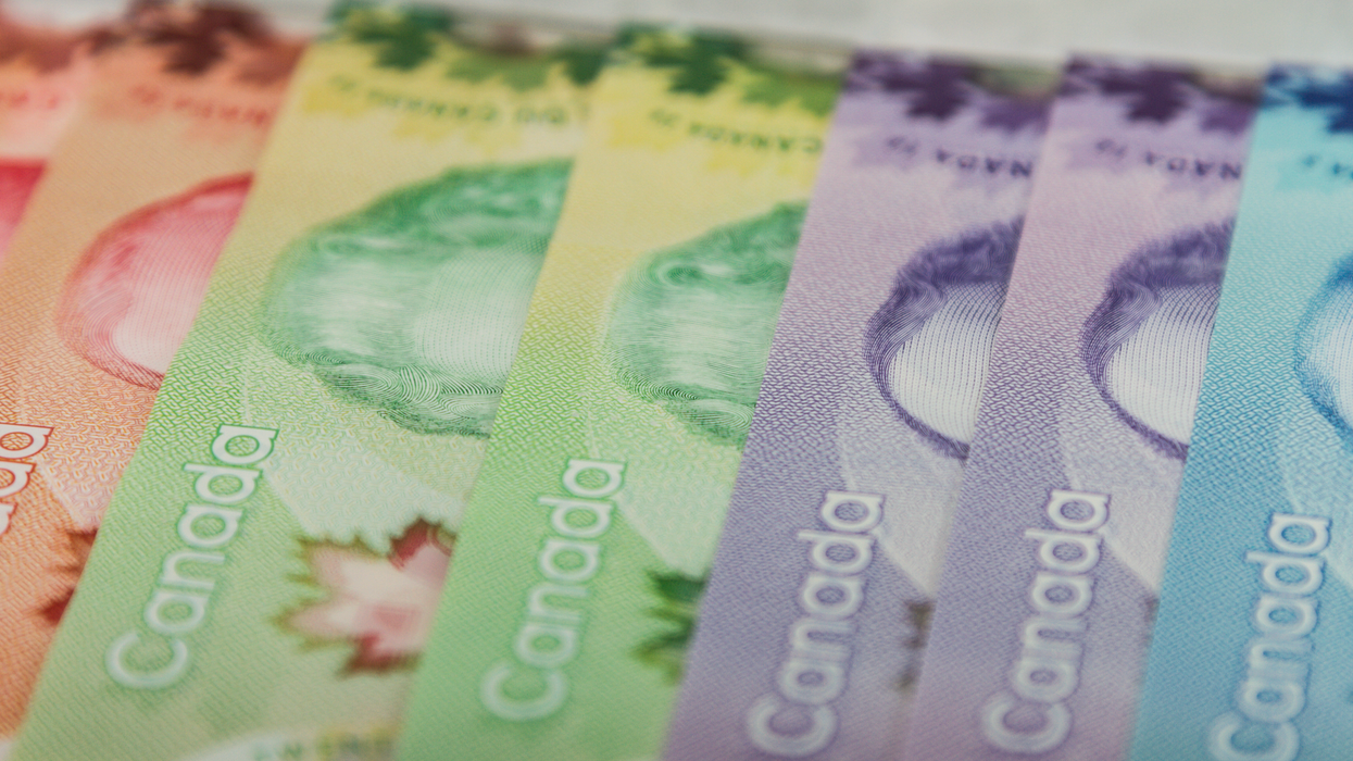 Des billets de 50 $, 20 $, 10 $ et 5 $ sont allignés sur une surface plane.