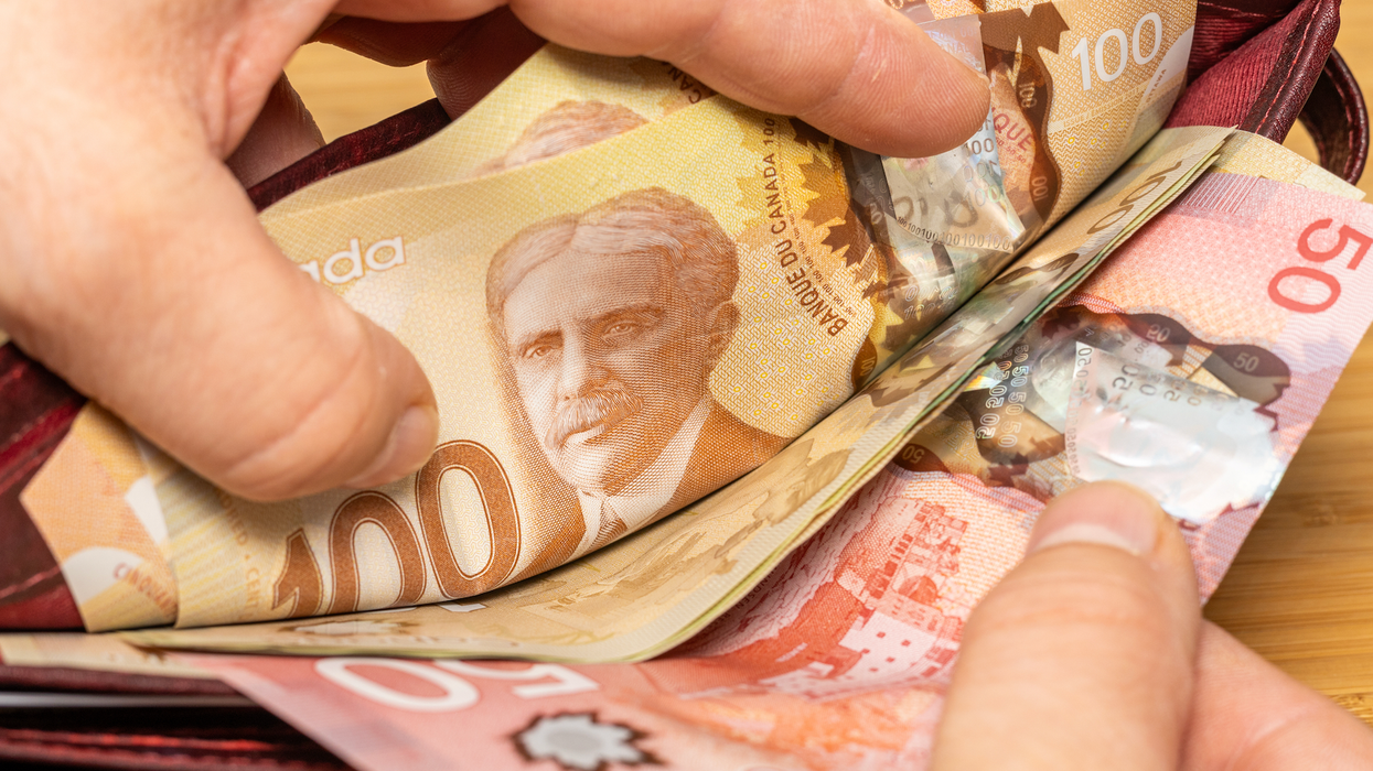 Des billets de 50 $ et 100 $ placés dans un portefeuille rouge.