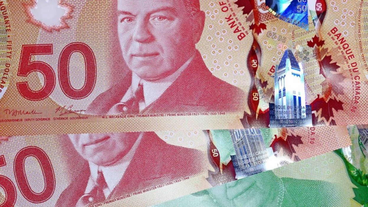 Des billets de 50 $ et de 20 $ sont étalés sur une surface plane.