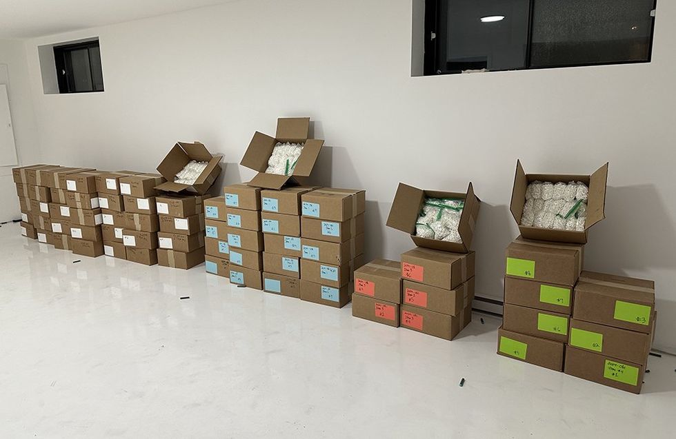 Des bo\u00eetes sont empil\u00e9s et certaines sont ouvertes, permettant de voir des sacs remplis de comprim\u00e9s de speed saisis par la police.