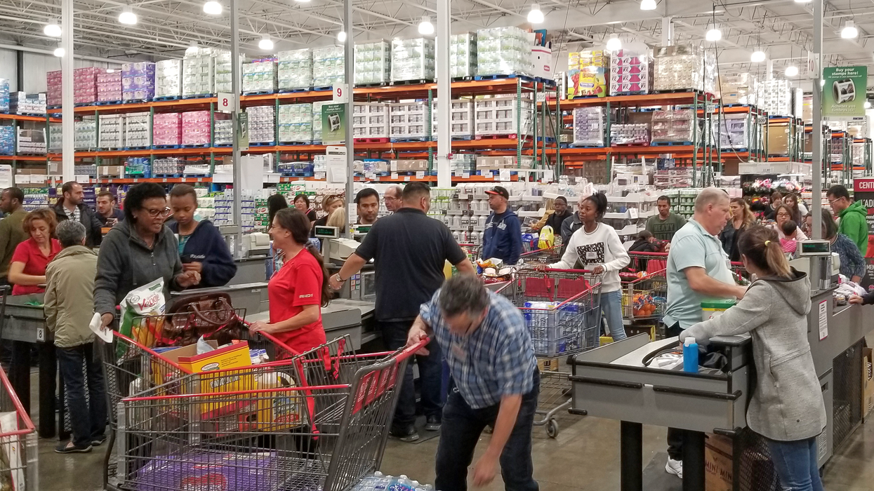 Des clients avec leur panier aux caisses d'un magasin Costco.