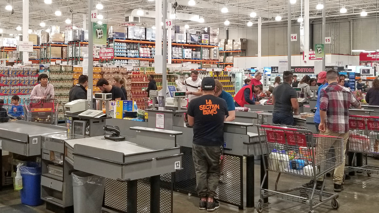 Des clients avec leur panier aux caisses d'un magasin Costco.