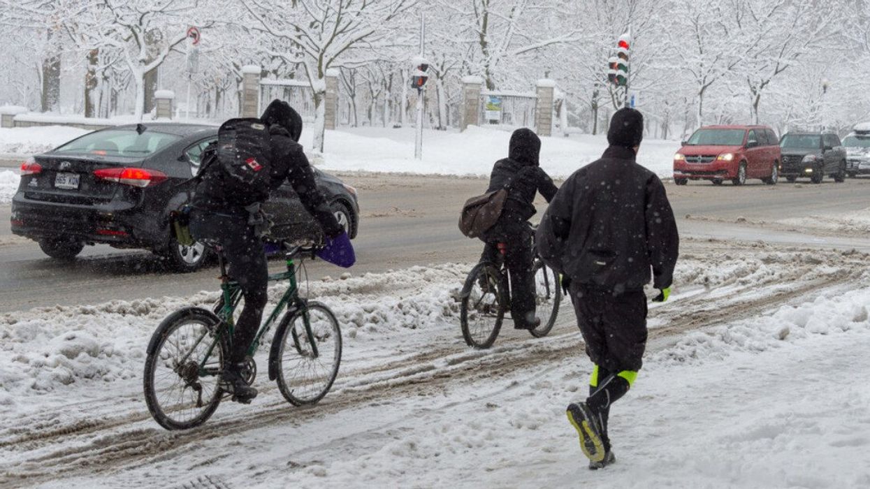 Des cyclistes et un joggeur dans le rues de Montréal en hiver.