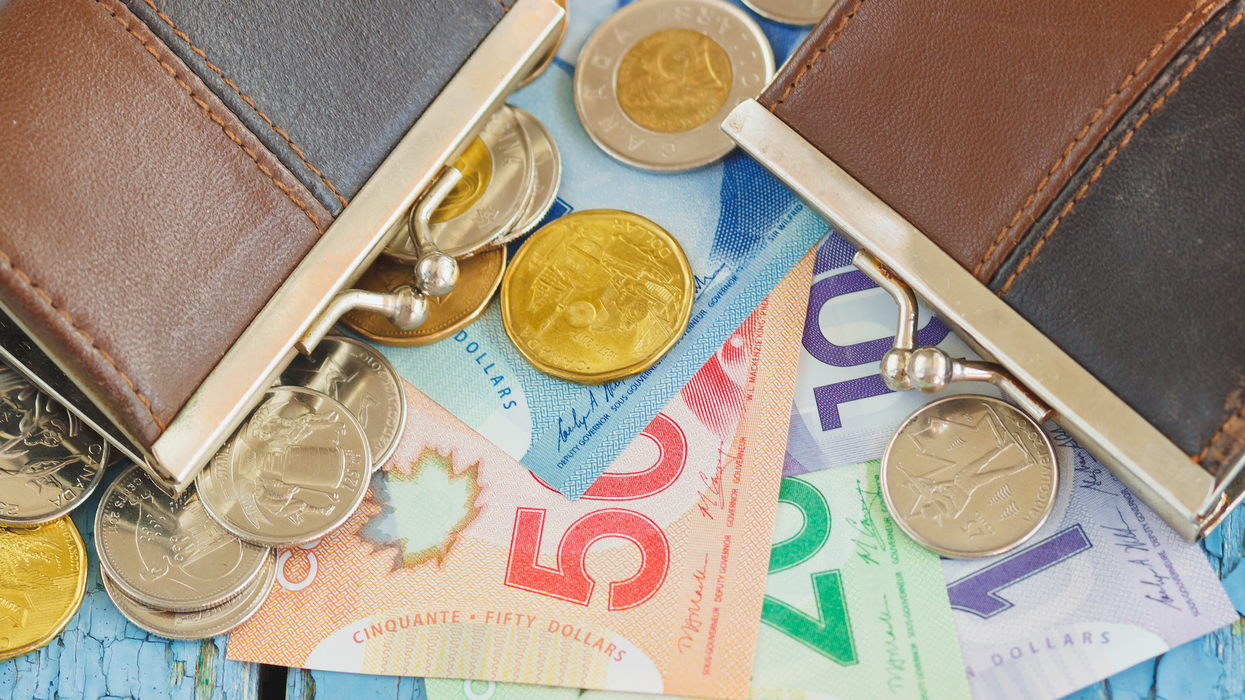 Des dollars et des billets d'argent canadien étalés sur une table avec deux porte-monnaies.