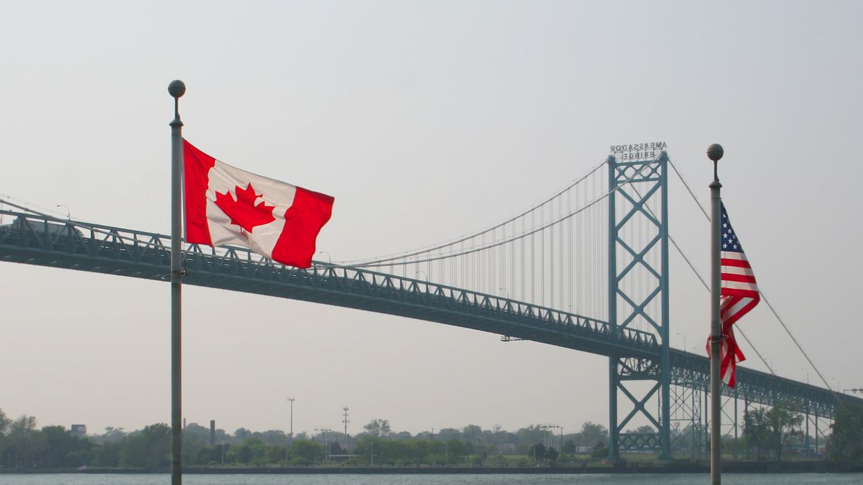 Des drapeaux canadien et américain devant le pont Ambassador.