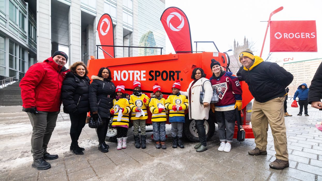 Des enfants et des adultes posent devant la Zamboni de Rogers.
