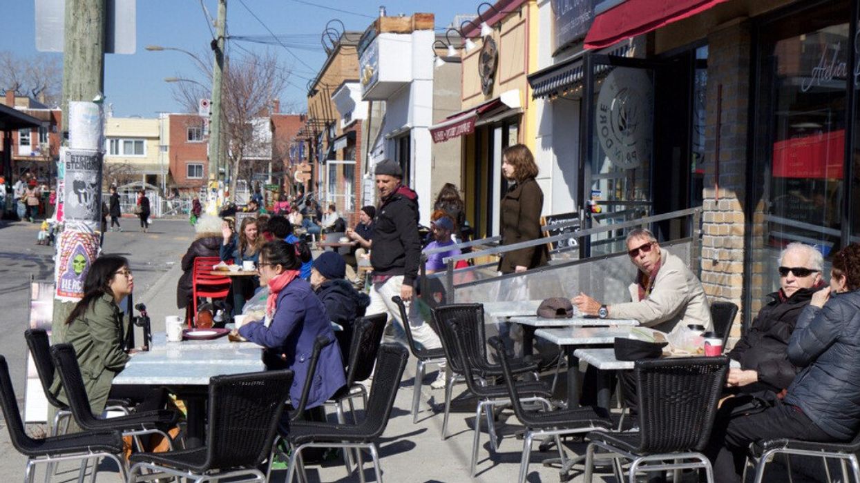 Des gens assis sur une terrasse à Montréal au printemps.