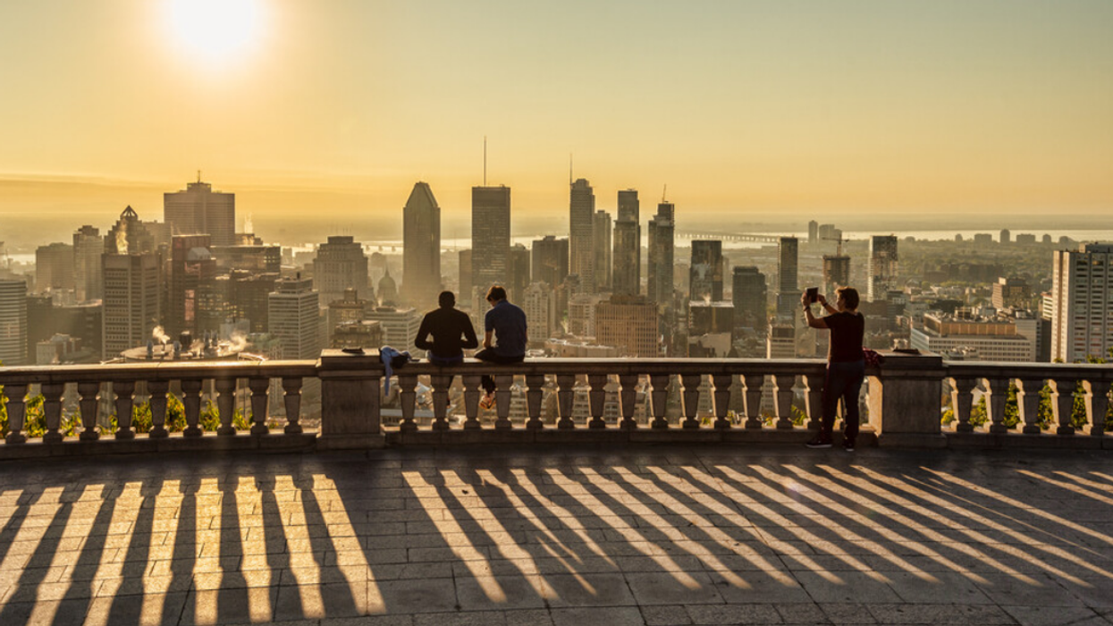 Des gens au belvédère du Mont-Royal regardent une vue de Montréal.