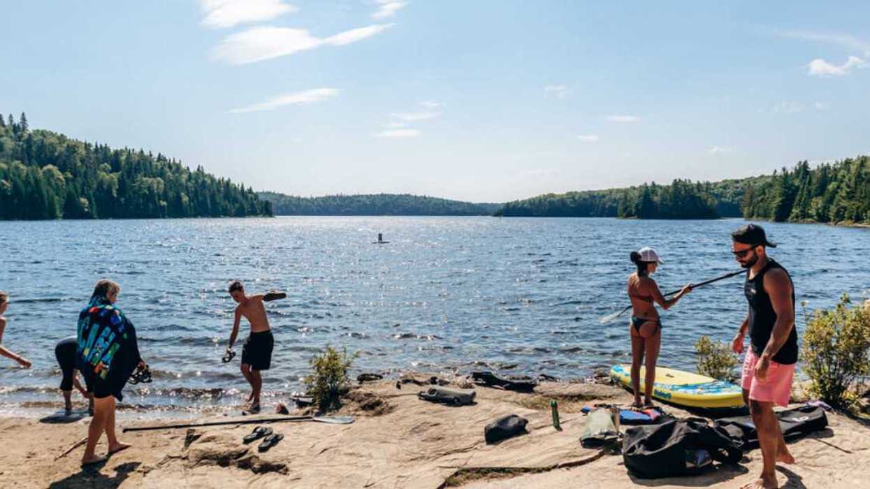 Des gens au bord d'un lac en été au Québec.