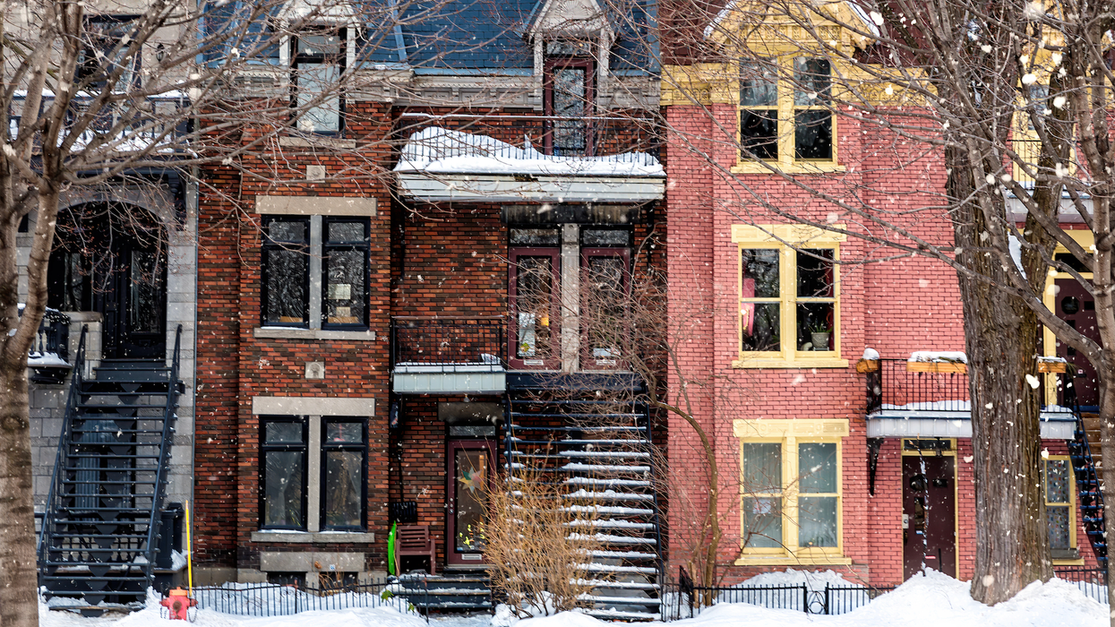 Des maisons colorées en rangée dans une rue enneigée à Montréal.