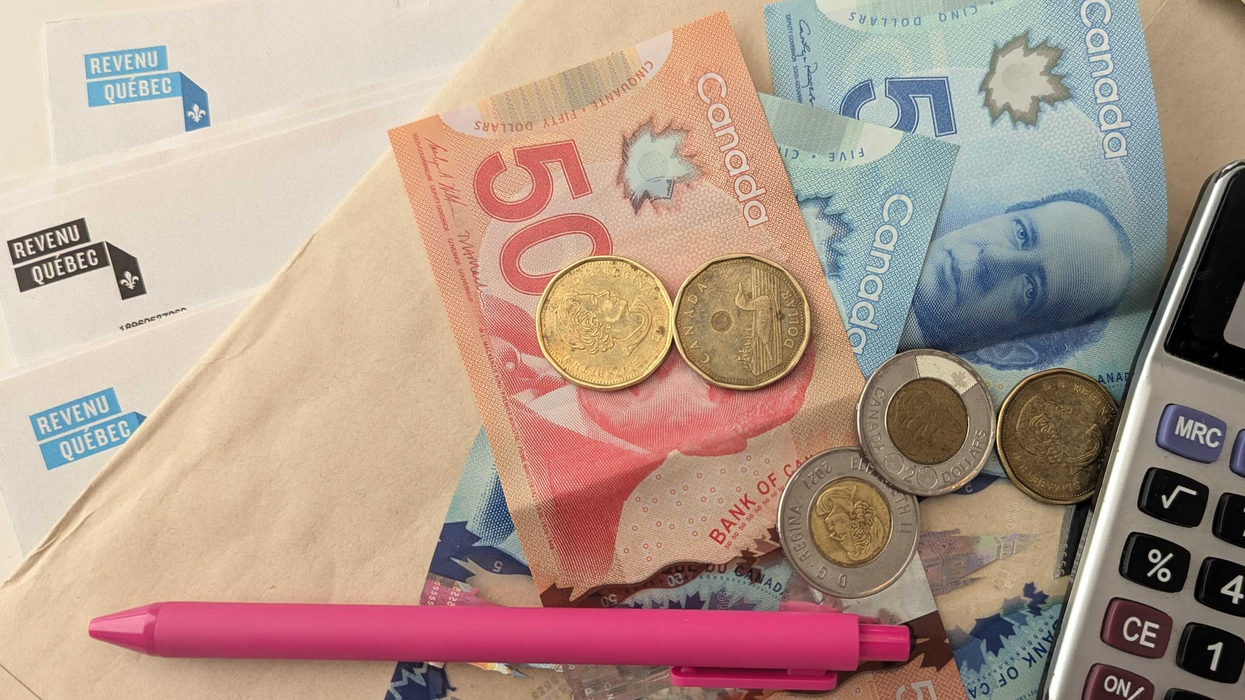 Des papiers de Revenu Québec, une enveloppe, des billets d'argent, de la monnaie, un crayon rose et une calculatrice sur une table.