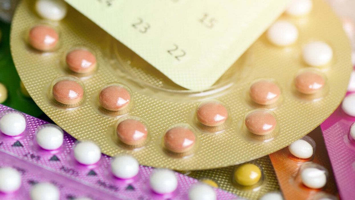 Des paquets colorés de pilules contraceptives sont étalés sur une surface plate.