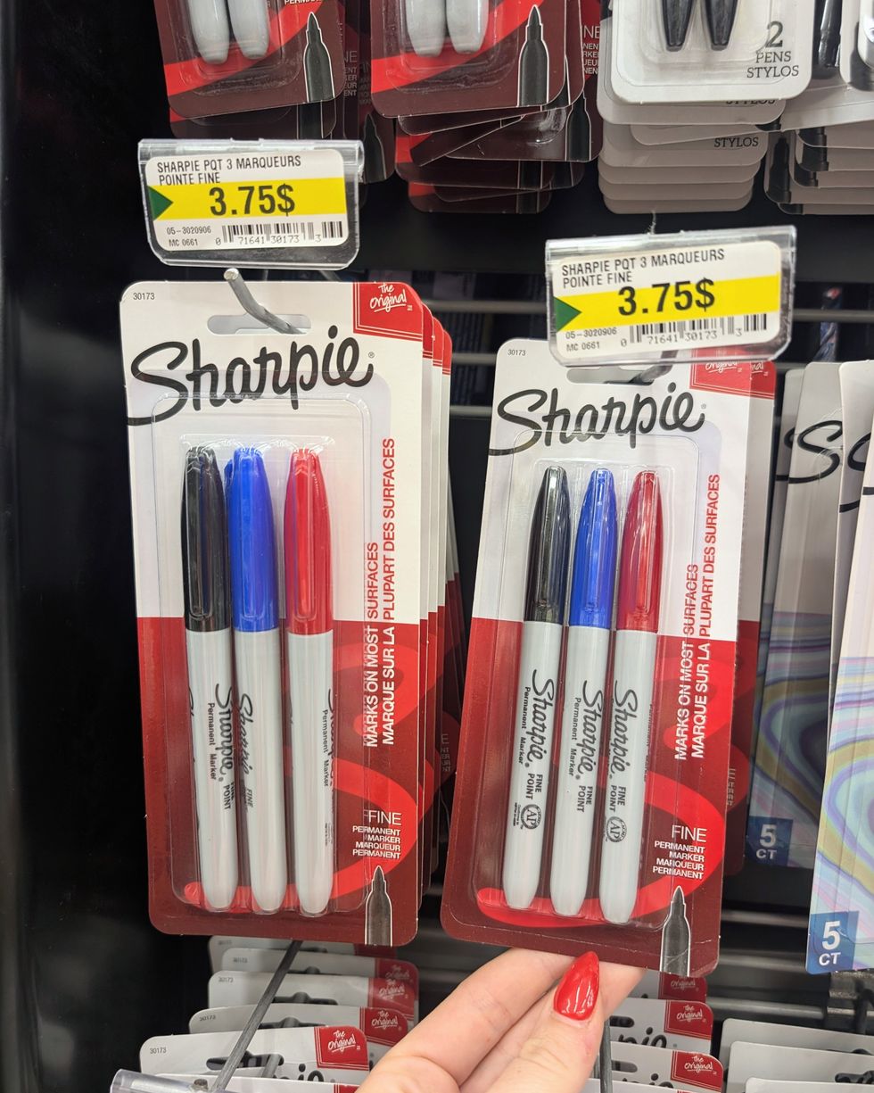 Des paquets de 3 marqueurs Sharpie noir, bleu et rouge vendus dans la rang\u00e9e des fournitures scolaires chez Dollarama.