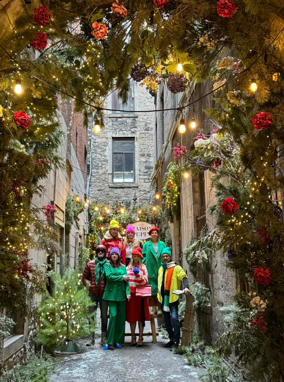 Des personnes aux habits color\u00e9s prennent la pose dans une ruelle de No\u00ebl.