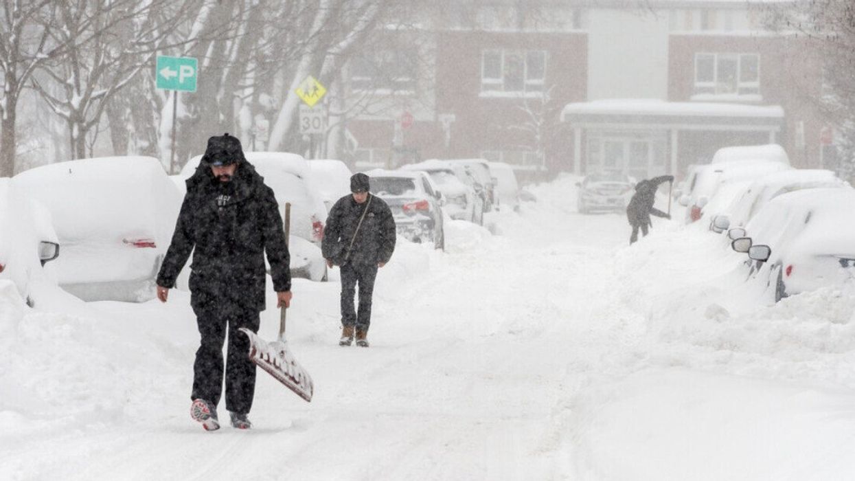 Des personnes avec leurs pelles dans les rues après une tempête de neige au Québec.