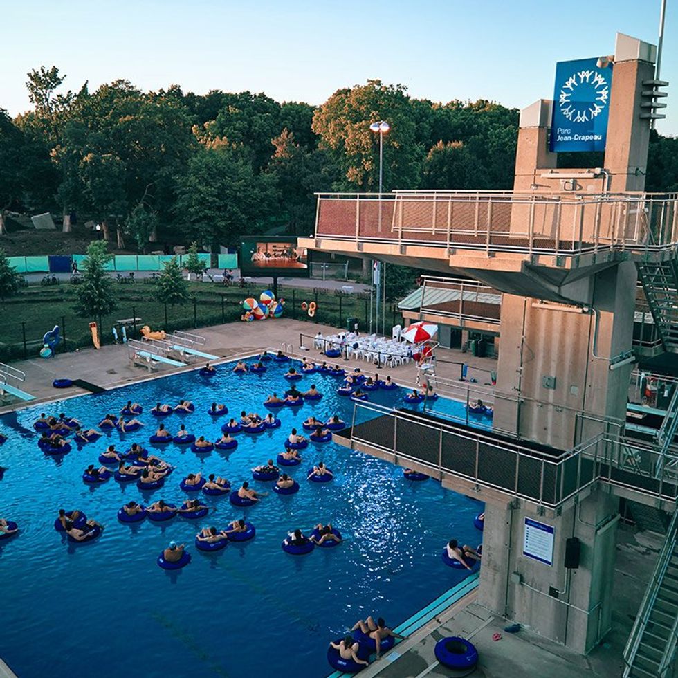 Des personnes dans une piscine \u00e9coutent un film, confortables dans leurs bou\u00e9es. 