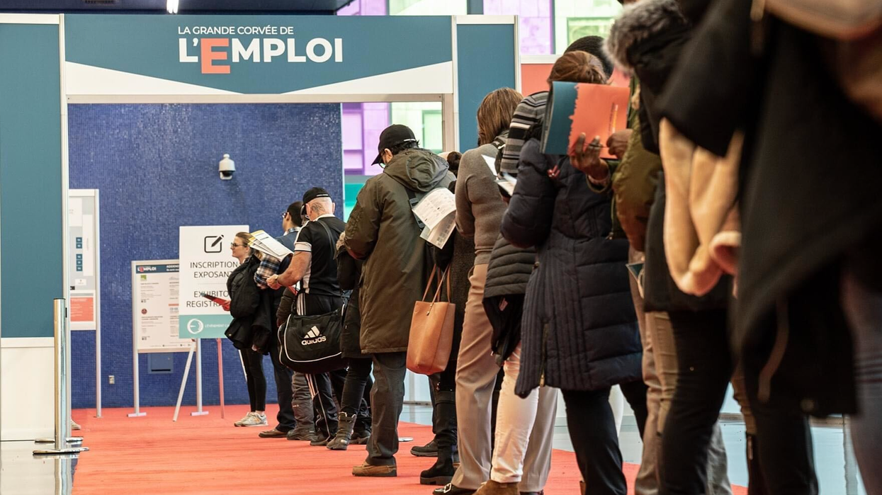 Des personnes font la file pour entrer dans un salon de l'emploi.