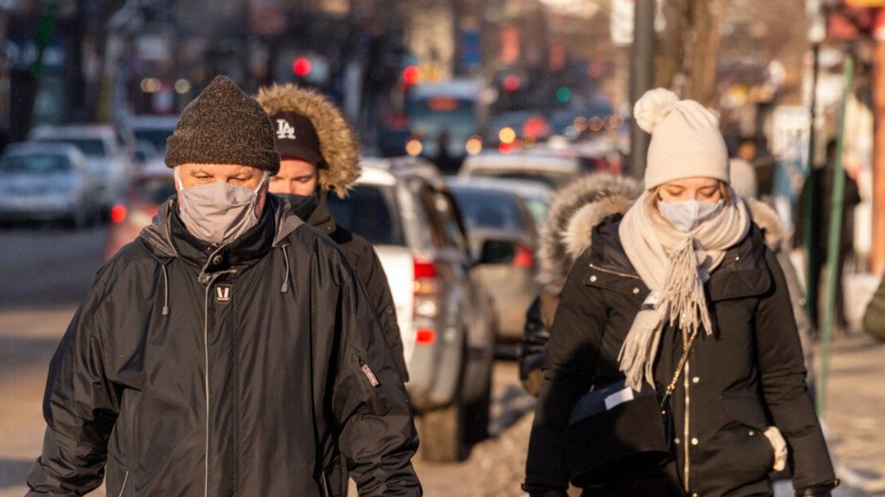 Des personnes marchent dans la rue à Montréal en hiver avec un masque.