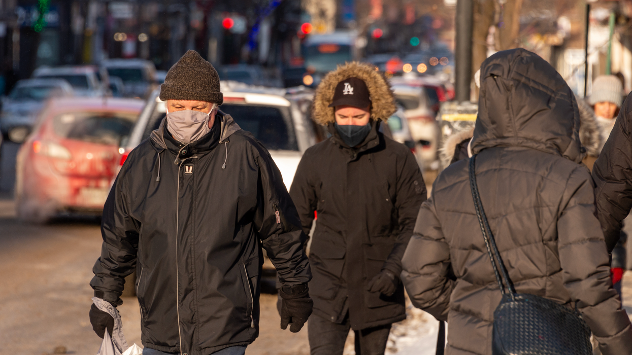 Des personnes marchent dans la rue avec un masque à Montréal.