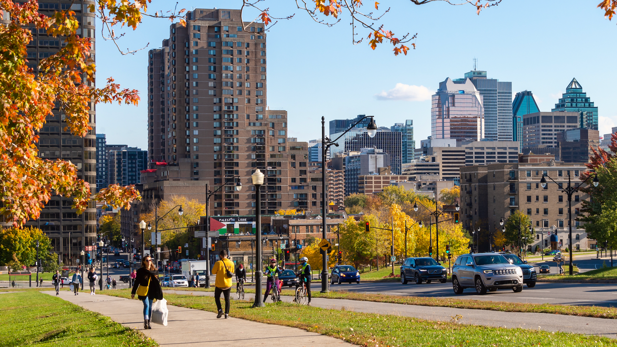 Des personnes marchent sur le trottoir à côté d'une rue à Montréal en automne.