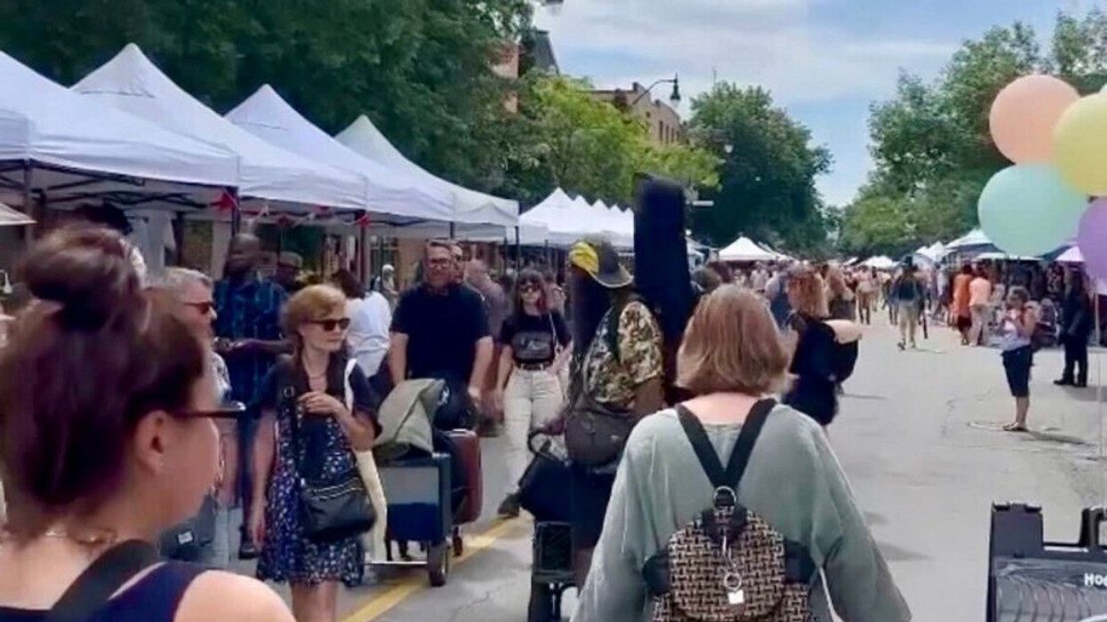 Des personnes passent devant des chapiteaux sur une rue à Montréal.