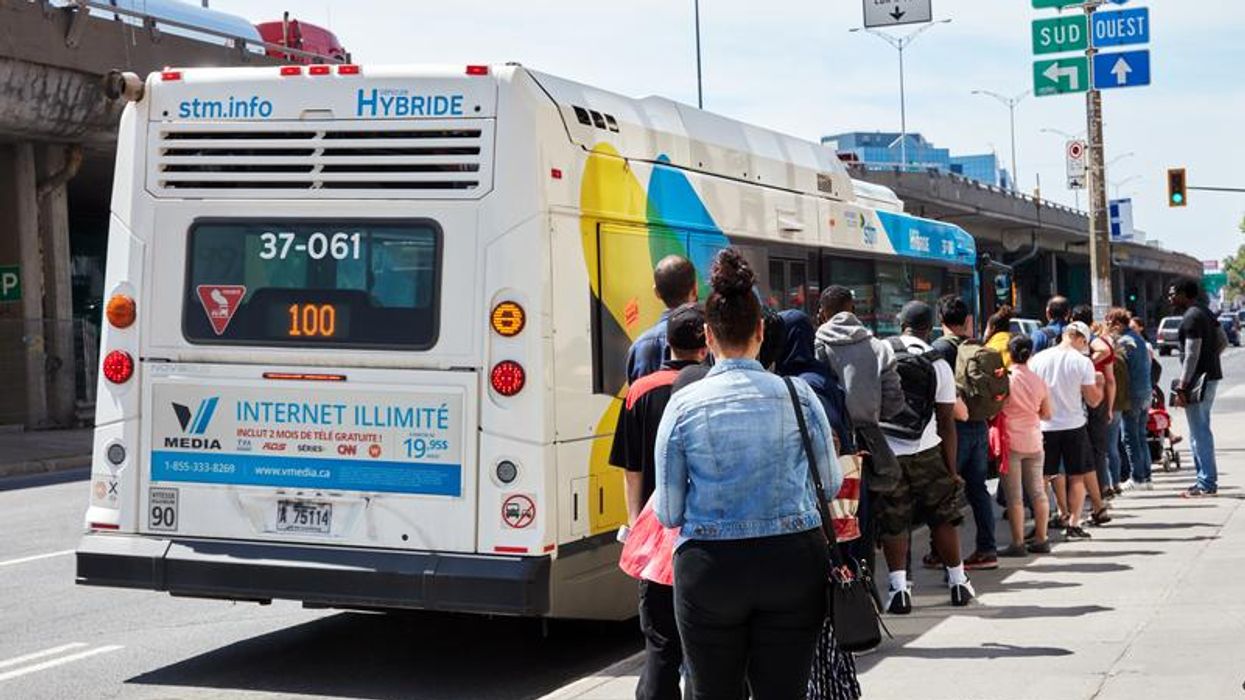Des personnes qui font la queue pour entrer dans un bus de la STM.
