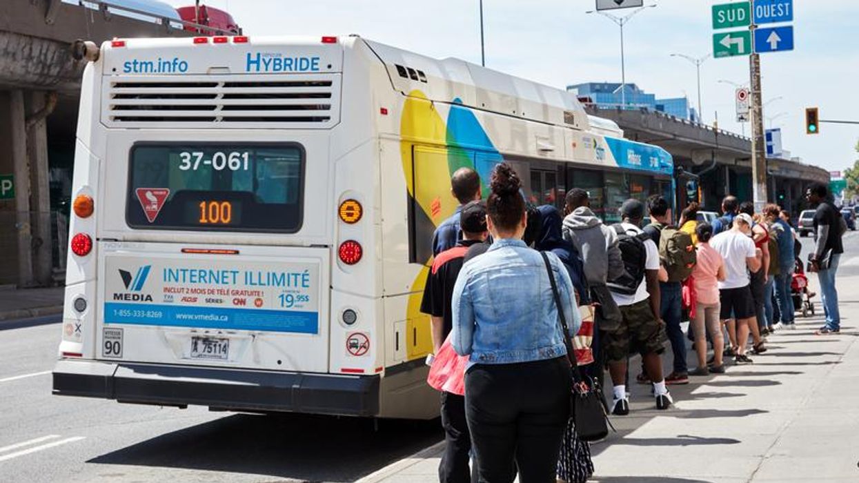 Des personnes qui font la queue pour entrer dans un bus de la STM.