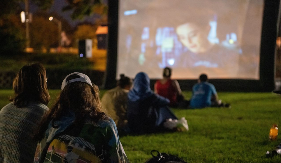 Des personnes regardent un film en plein air.