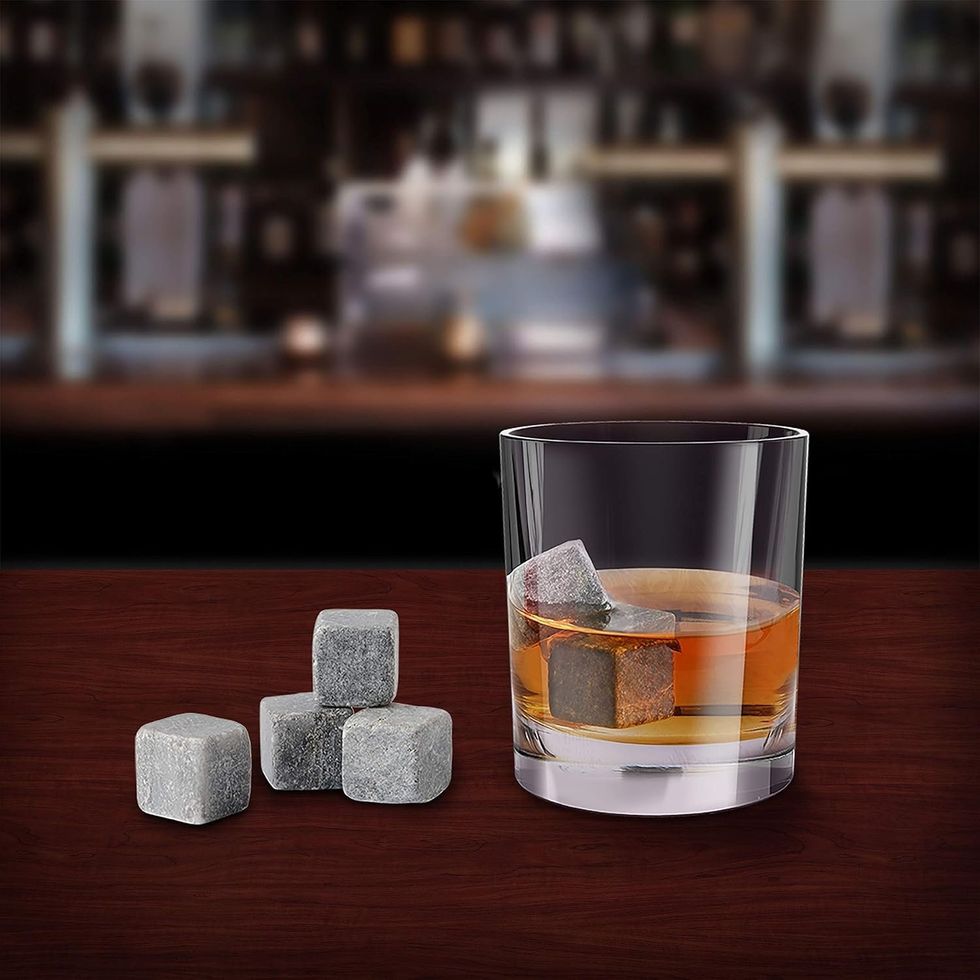 Des pierres \u00e0 whisky dans un verre et sur un bar.